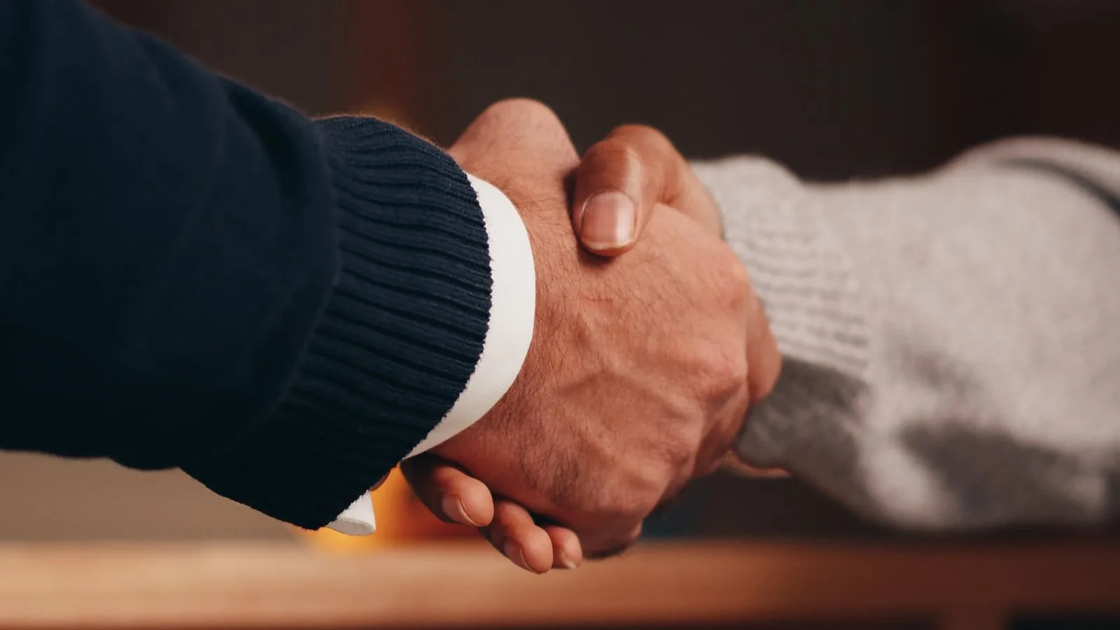 Dos personas cerrando un acuerdo con un apretón de manos
