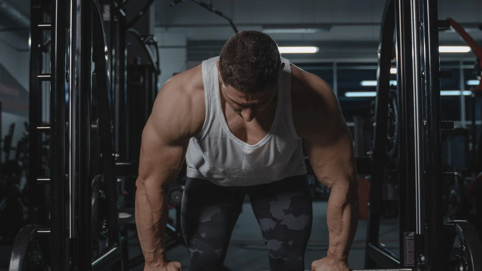 Una sola persona entrenando en un gimnasio vacío y en penumbra