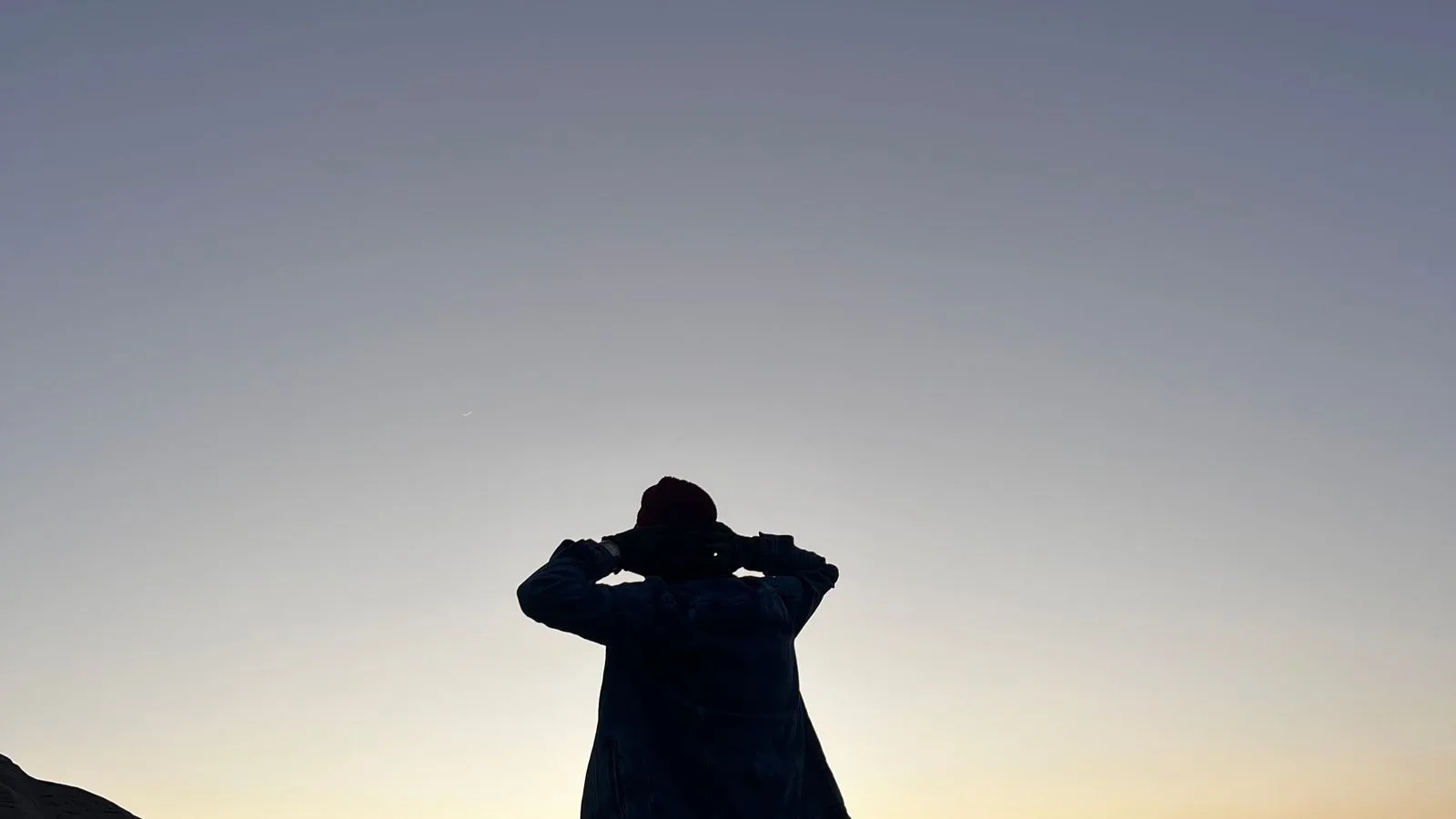 La silueta de una persona mirando el amanecer desde la cima de una montaña