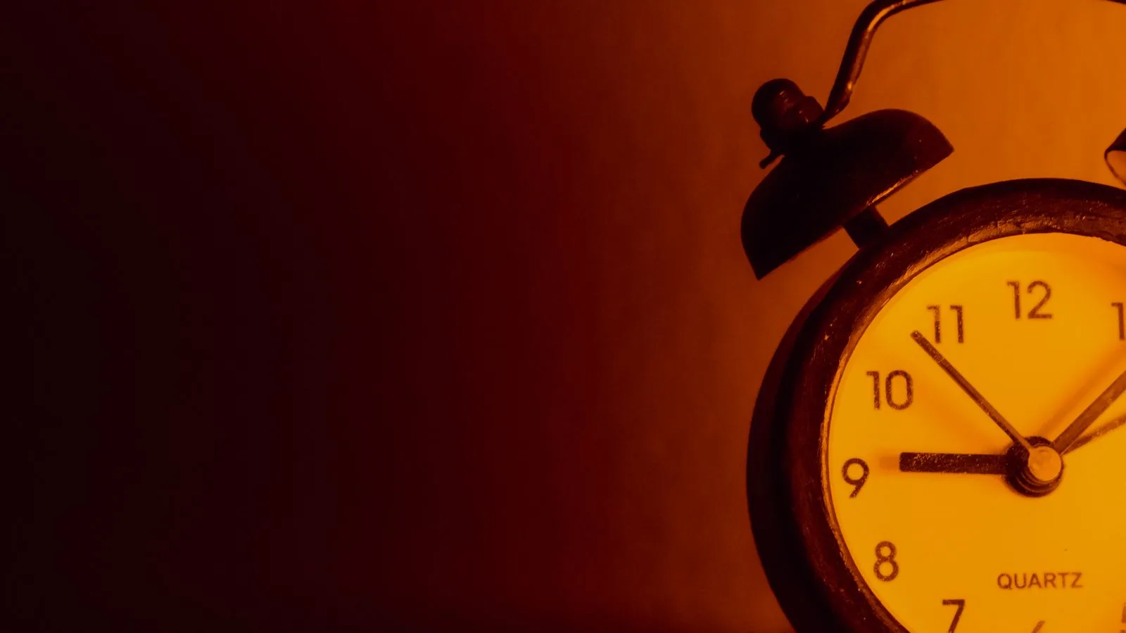 Un reloj despertador en la oscuridad, apenas iluminado