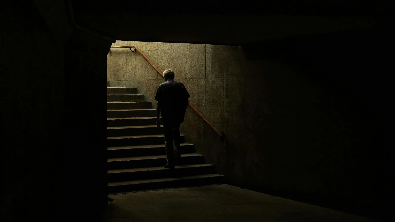 Una persona subiendo unas escaleras en un túnel oscuro