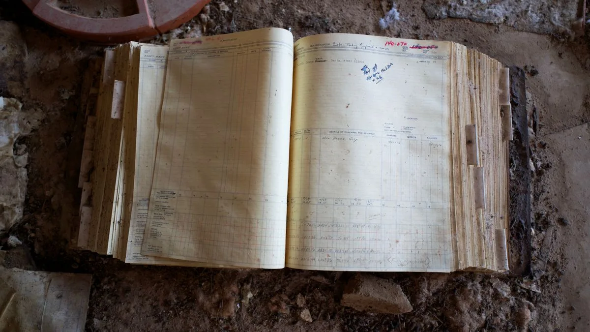 Un cuaderno antiguo abierto y abandonado, cubierto de polvo