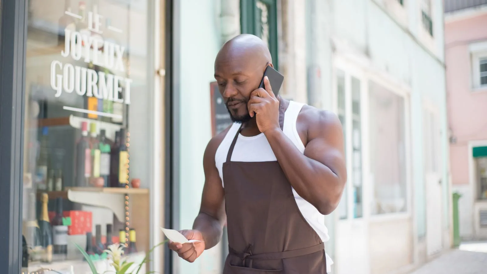 Comerciante atendiendo por teléfono en su propio local